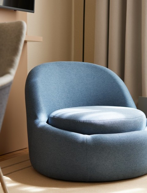 Moderner, gemütlicher blauer  Sessel in stilvollem Apartment für komfortables Wohnen auf Zeit in Hannover mit hochwertiger Einrichtung