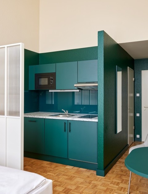 Modernes Apartment mit einer Küchenzeile, einem Tisch und Bett – stilvolles Wohnen auf Zeit Hannover in durchdachtem Design