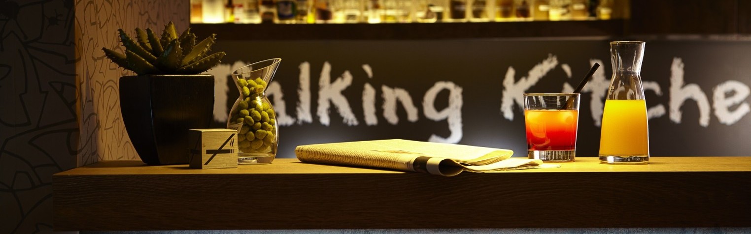 Eine Bar mit Getränken, Zeitung und Wasabinüssen – entspannter Ausklang in der stilvollen Talking Kitchen Hannover