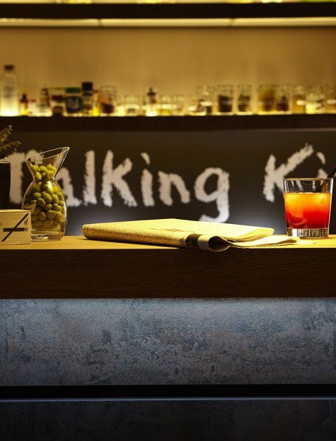 Eine Bar mit Getränken, Zeitung und Wasabinüssen – entspannter Ausklang in der stilvollen Talking Kitchen Hannover