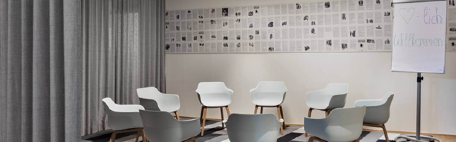 Kleiner Meetingraum in Hannover, mit Stuhlkreis, Flipchart und grauen Vorhängen, ideal für Workshops oder Gruppenarbeit