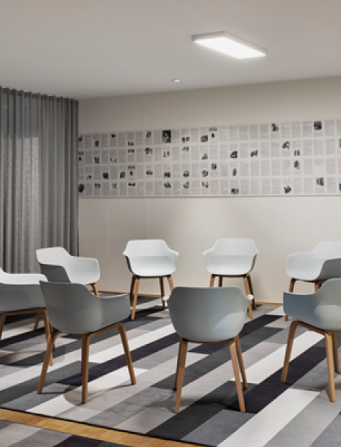 Kleiner Meetingraum in Hannover, mit Stuhlkreis, Flipchart und grauen Vorhängen, ideal für Workshops oder Gruppenarbeit