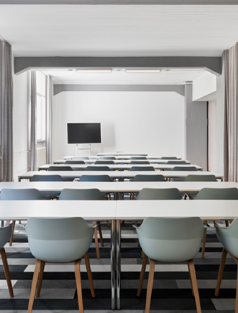 Moderner Tagungsraum in Hannover, mit Reihenbestuhlung, Fernseher, Tageslicht und grauen Vorhängen für flexible Nutzung